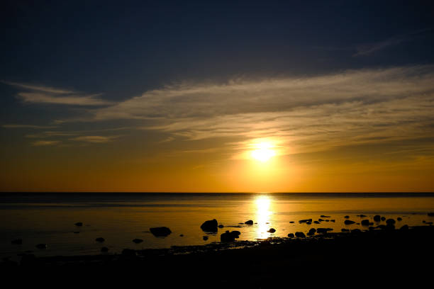 istock dramatic sunset over the calm sea shore with rocks 970057780