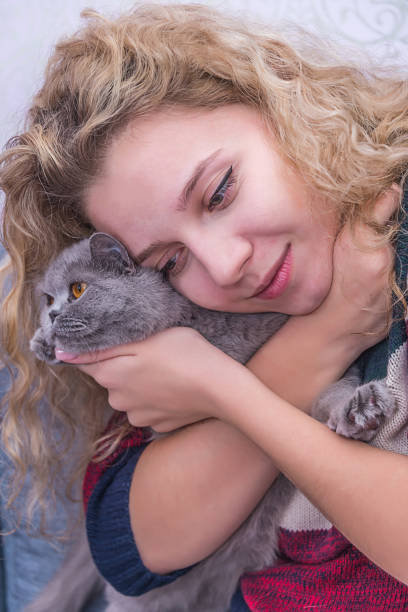 istock girl hugging a grey cat 970060330
