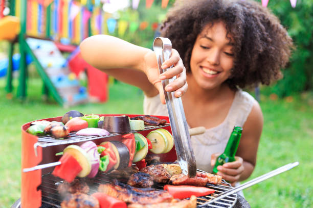 istock Smiling woman preparing barbecue at backyard 970060760