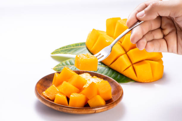 istock Fresh and beautiful mango in a wooden plate with sliced diced mango chunks isolated with   white background, copy space(text space), blank for text 970064096