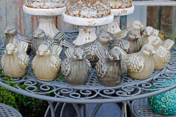 istock Ceramic birds and vintage rusty candlesticks stand on the openwork table in a flower shop 970064620