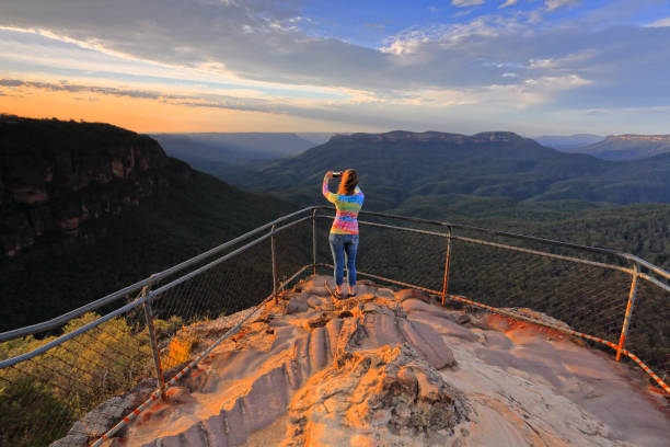 istock Woman capturing a sunrise in Mountains 970070868