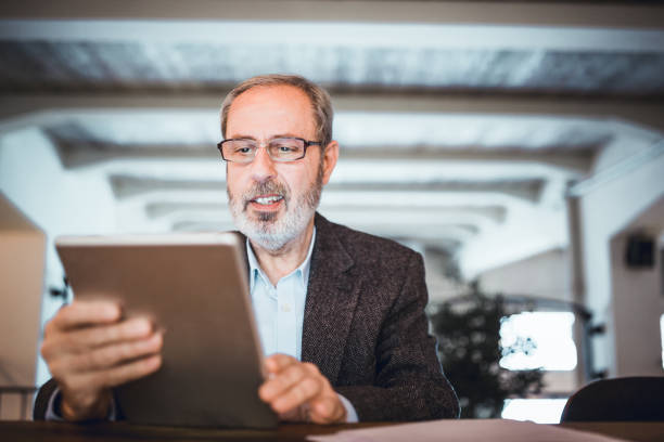 istock Mature businessman working at the bar in high end restaurant using digital tablet 970078484