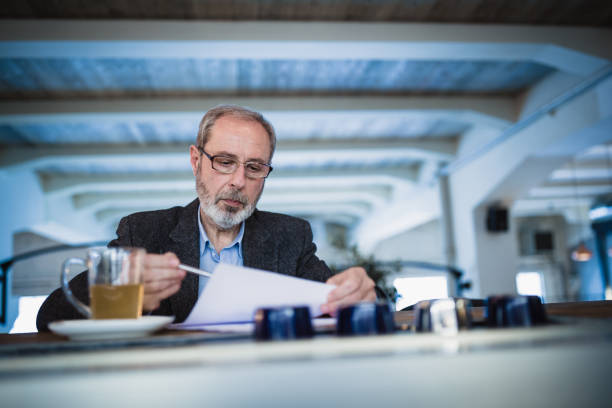 istock Mature businessman working at the bar in high end restaurant using digital tablet 970078510