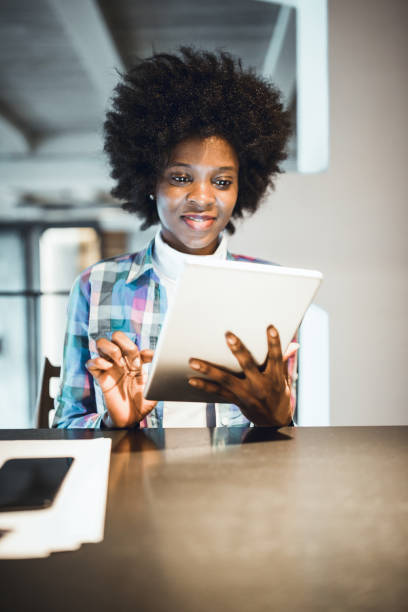 istock Young woman, African-American Ethnicity, using digital tablet in high end restaurant 970078652