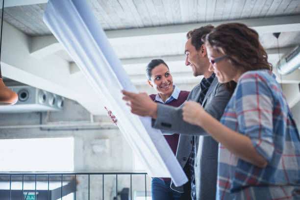istock Group of young architects examine the blueprint 970085730