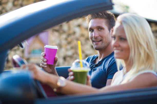 istock Young couple on a road trip with drive-in drinks 970086022