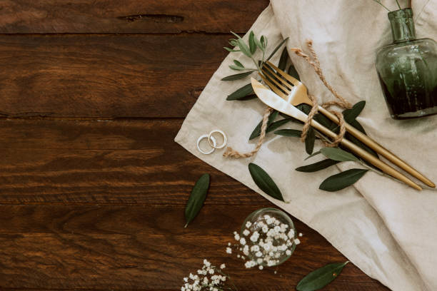 istock Wedding rings and table cutlery on rustic background. Boho decorations 970090466