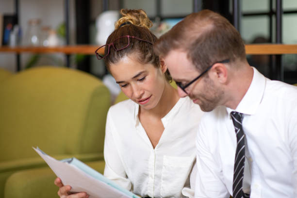 istock Serious coworkers discussing document in office lobby 970094492