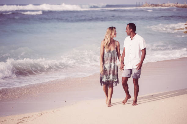 istock Content Couple Chatting and Walking on Beach 970096354