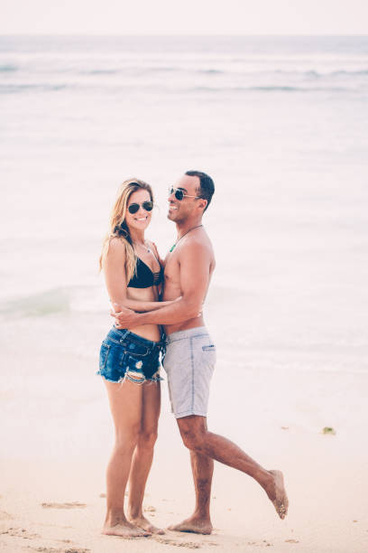 istock Happy young couple embracing on beach in summer 970096974