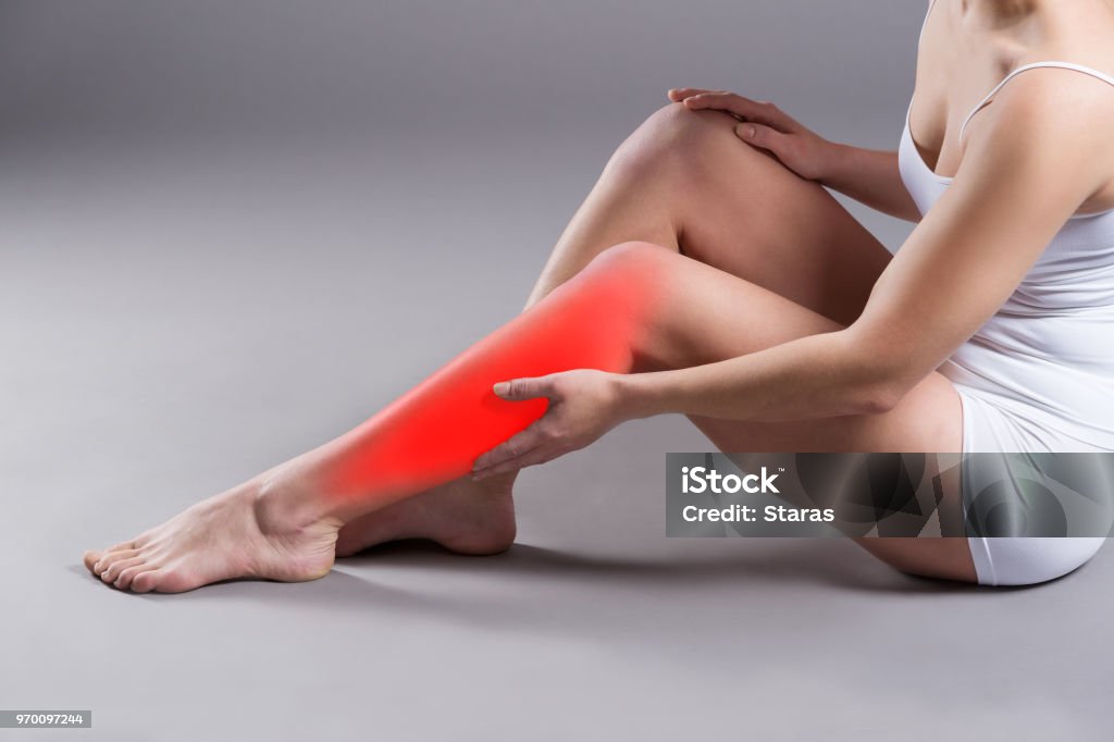 Douleur au tibia de la femme, massage de jambe de femme sur fond gris - Photo de Jambe libre de droits