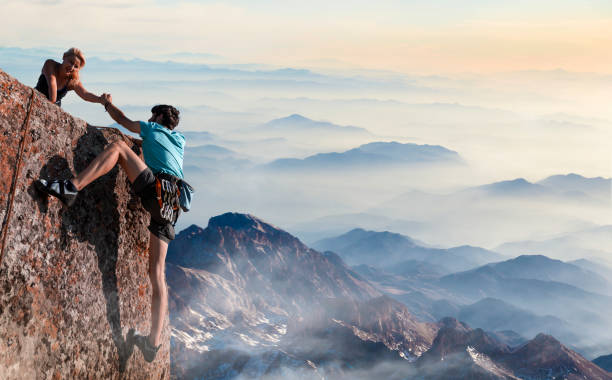 teamwork paar helpende hand vertrouwen in inspirerende bergen - vertrouwenspersoon stockfoto's en -beelden