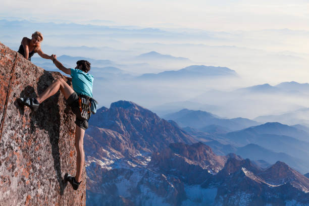 istock Teamwork couple helping hand trust in inspiring mountains 970101734