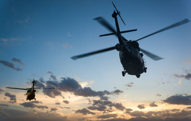 istock Military Helicopters flying against sunset 970105306