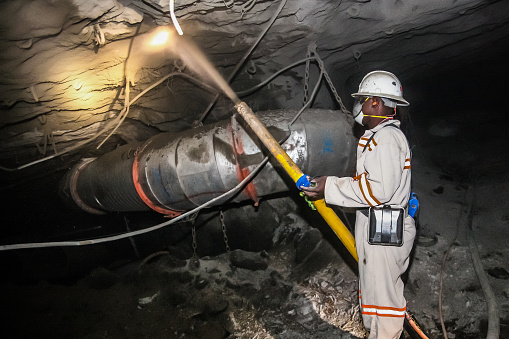 Rustenburg, South Africa, May 23, 2011, Underground Platinum Chrome miners spraying liquid cement for wall and roof reinforcement