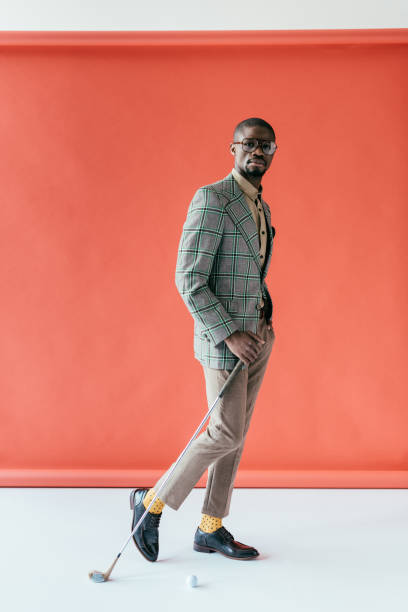 istock handsome stylish african american man playing golf, on red 970108778