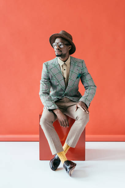 istock stylish african american man posing in retro hat, on red 970108982