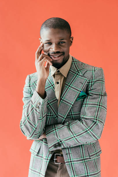 istock handsome smiling african american man posing in vintage jacket, isolated on red 970110080