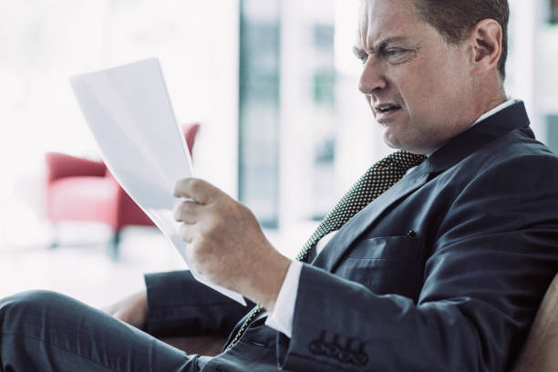 istock Displeased senior businessman reading document 970110302