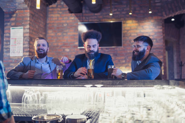 istock Three businessman having fun after work, sitting on the bar counter 970110472