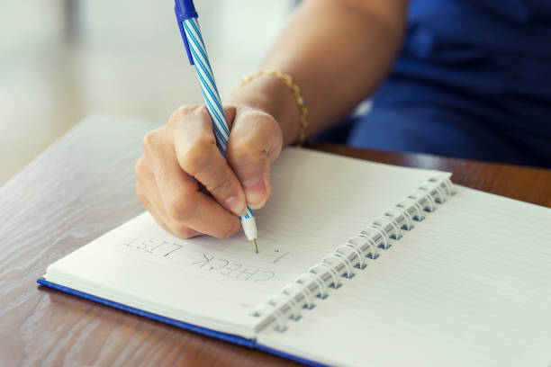 istock Woman hand writing check list on notebook, planning concept. 970114442