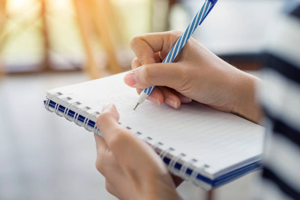 istock Woman hand writing check list on notebook, planning concept. 970114540