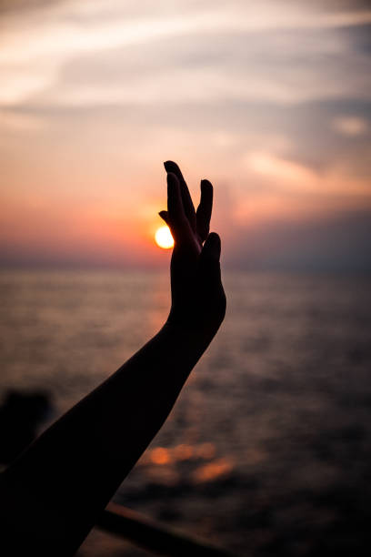 istock A hand pointing toward the sun during sunset 970117530