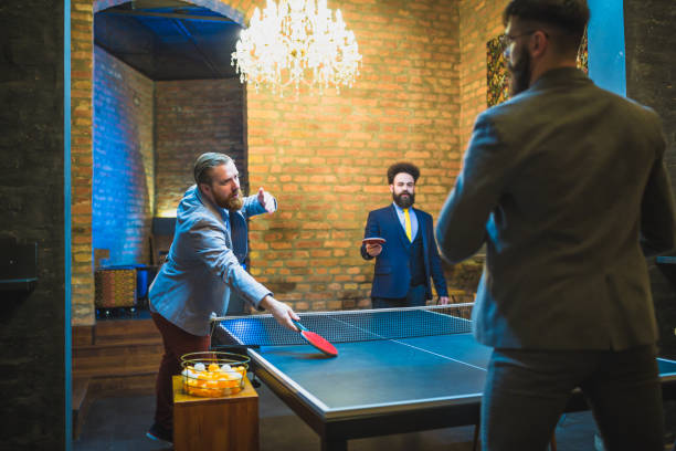 istock Group of young businessman playing table tennis after work 970117568