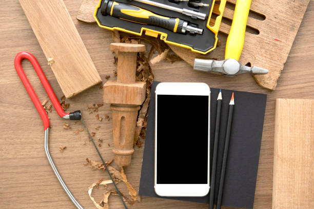 smart phone on work shop space top view with carpentry and home improvement construction tools.industrial and DIY concept smart phone on a work shop space top view with carpentry and home improvement construction tools.industrial and DIY concept diy table legs stock pictures, royalty-free photos & images