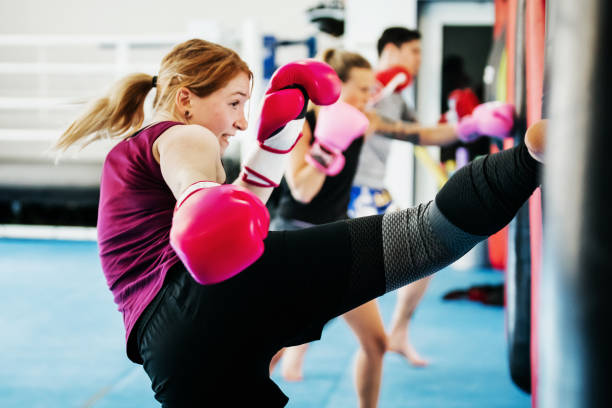 Group Of Women Kickboxing Together At Gym A group of women kickboxing and training together at their local gym. kickboxing photos stock pictures, royalty-free photos & images