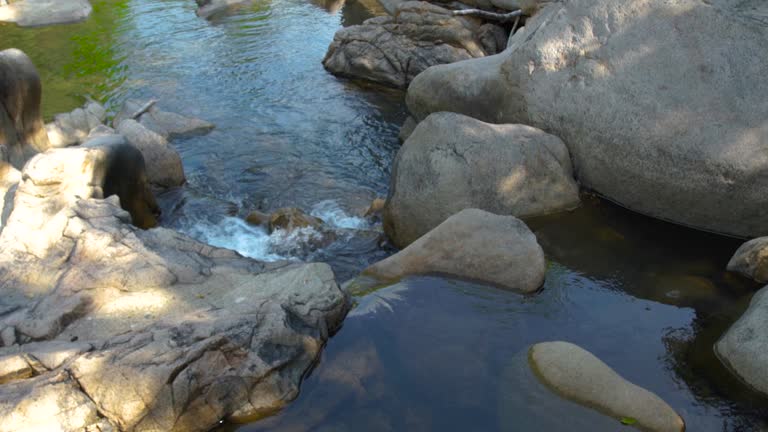 Large stones and rocks in mountain river. Mountain waterfall and stony river in tropical forest. Rapid river flow between big stone creating waterfall