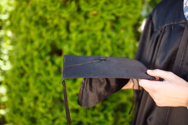 istock Successful graduate, in academic dresses, holding a graduation cap farewell study, can be used for advertising, text insertion 970127738