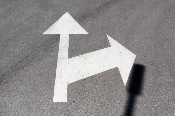 istock Traffic arrows painted white on asphalt road 970129048