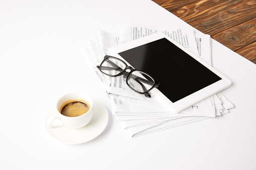 eyesight, cup of coffee, newsprint and digital tablet with blank screen, on white