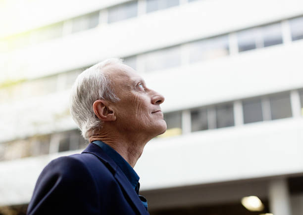 istock Confident businessman looks up at office building 970152496