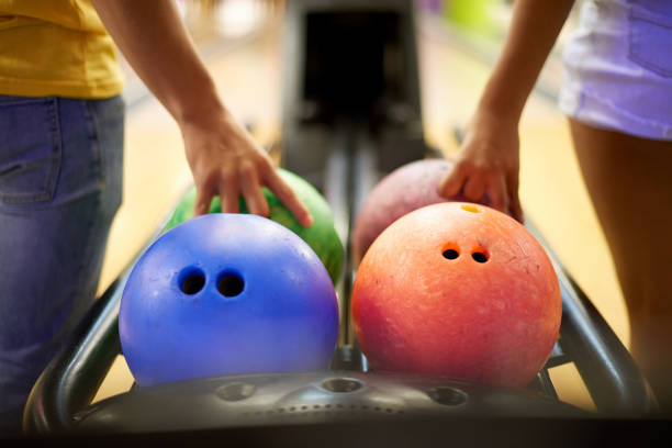 Together we got this Cropped shot of an unrecognizable couple grabbing a bowling ball in a bowling alley clingy girlfriend stock pictures, royalty-free photos & images