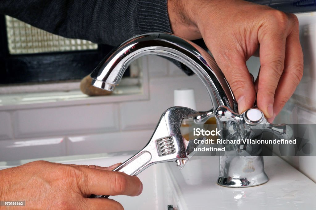Repairing a faucet Faucet Stock Photo