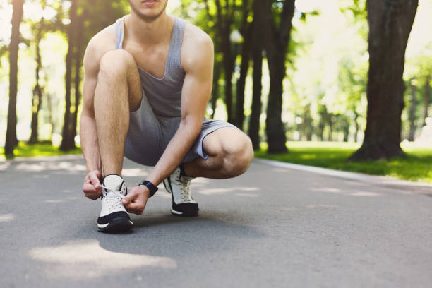 istock Unrecognizable man tying shoelaces before running 970160536