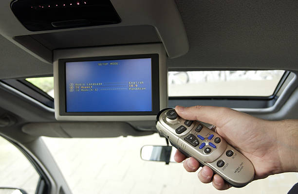 Remote control for car DVD Hand holding remote control for car entertainment center, shallow DOF focus on hand and remote. remote control for car dvd stock pictures, royalty-free photos & images