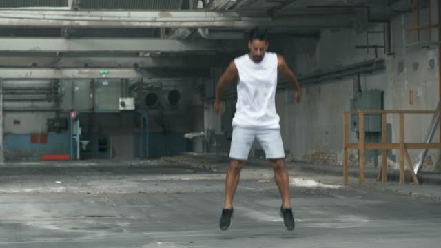 Man doing Jumping Exercises in an Abandoned Warehouse