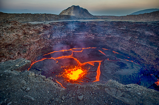 View from the crater rim of Erta Ale - one of the most active vulancoes in the world - into the active, red glowing lava lake. Erta Ale is a continuously active basaltic shield volcano in the Afar Region of northeastern Ethiopia, only some kilometers from the border to Eritrea.

The Afar Depression (or Danakil Depression) in the border-triangle between Ethiopia, Eritrea and Djibouti is one of the most remote and most extreme regions of the world - it is the lowest point in Africa (- 155 metres/-550 ft below sea level) and one of the hottest places on Earth.

The Danakil/Afar Depression is the product of a tectonic triple junction, where the spreading ridges that form the Red Sea and the Gulf of Aden emerge on land and meet the East African Rift. Here the Earth's crust is slowly rifting apart at a rate of 1–2 centimetres (0.3–0.8 in) per year.

Erta ale is ond of the most dangerous places on earth - the lat major eruptions took place in September 2005, August 2007 and November 2008.
