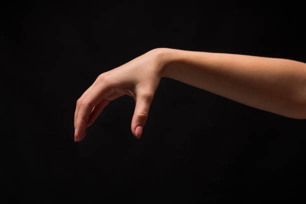 istock Female hand picking up something, cutout on black 970179378