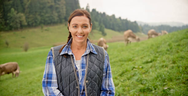 Portrait of woman Portrait of veterinarian with cows grazing in background. gray eyes photos stock pictures, royalty-free photos & images
