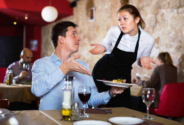 zły człowiek skarży się na przeprosiny kelnerka o jedzenie w restauracji - expensiveness zdjęcia i obrazy z banku zdjęć