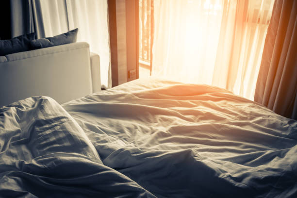 istock unmade rumpled bed with white messy pillows  in bedroom interior morning light 970224188