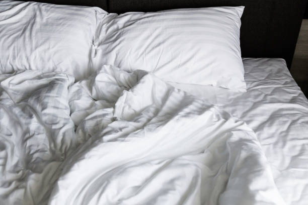 istock unmade rumpled bed with white messy pillows  in bedroom interior morning light 970224206