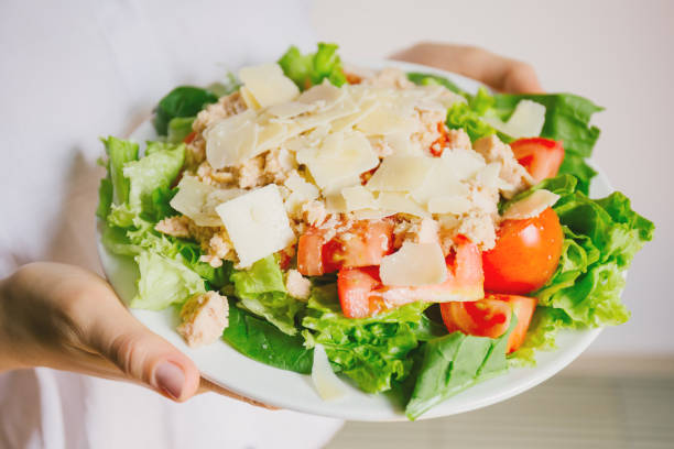 Girl holding healthy salad ready to eat Young girl hoding tasty fresh salad ready for dinner. Closeup horizontal kids eating tuna stock pictures, royalty-free photos & images