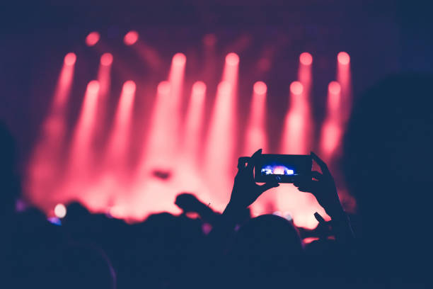 istock Hands using camera phone to take pictures, videos at concert 970228090