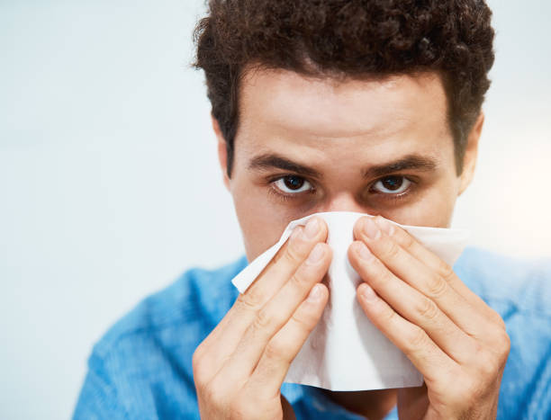 istock Young man with flu or a cold blows his nose 970232400